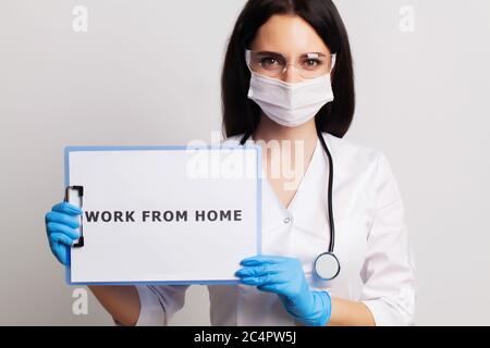 Femme médecin dans une couche blanche tenant le travail d'inscription de la maison Banque D'Images