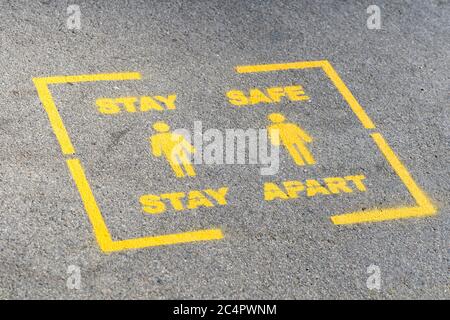 Un stencil peint Stay Safe Stay Apart sur une plate-forme de gare britannique pendant la pandémie du coronavirus Covid-19 Banque D'Images