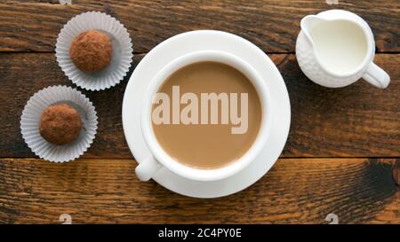 Tasse à café avec truffes à la crème et au chocolat sur table en bois, vue sur le dessus Banque D'Images