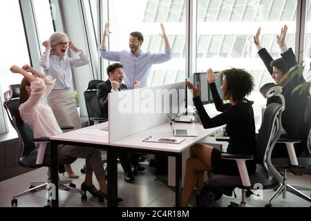 Un groupe de gens d'affaires enthousiastes triomphant sur le lieu de travail Banque D'Images
