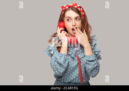 Ouah ! Surprise pinup fille tenant téléphone combiné surpris par la conversation, couvrant sa bouche ouverte choquée par des nouvelles incroyables, discutant des rumeurs sur t Banque D'Images