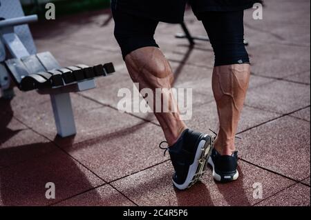 des jambes d'athlète fortes dans des baskets sur terrain d'entraînement en plein air en été Banque D'Images