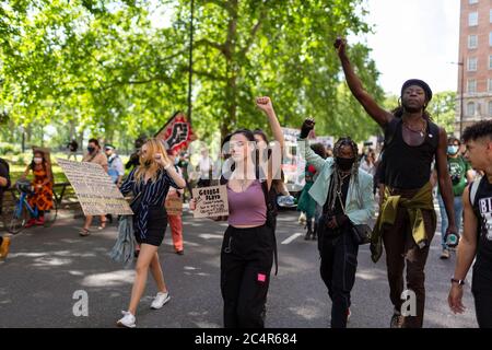 Des manifestants en marche élèvent leurs poings lors d'une manifestation Black Lives Matter, Londres, 20 juin 2020 Banque D'Images