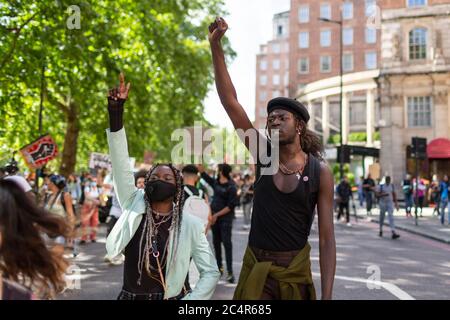 Des manifestants en marche élèvent leurs poings lors d'une manifestation Black Lives Matter, Londres, 20 juin 2020 Banque D'Images