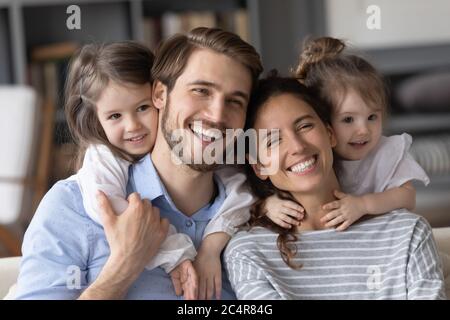 Tête portrait deux petites filles piggy soutenant heureux parents Banque D'Images