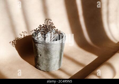 Résumé créatif composition minimale avec un pot d'argile et de l'herbe sèche contre papier kraft. Concept des produits naturels et écologiques. Banque D'Images