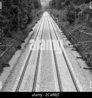 Photo en noir et blanc de deux voies de chemin de fer menant à la distance. Symbole de deuil, de perte et de tristesse. Banque D'Images