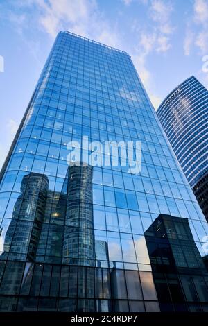 Le bâtiment de la défense de coeur se reflète dans le gratte-ciel opposé et les immeubles de bureaux dans le quartier d'affaires de la Défense, Paris, France Banque D'Images