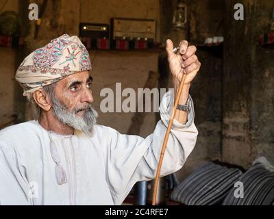 Vieil homme dans une maison classique de construction de boue à Bait Al Safah, Al Hamra, Sultanat d'Oman. Banque D'Images