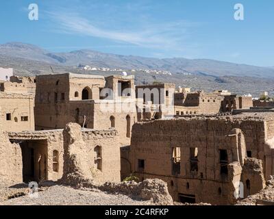 Vue extérieure d'une construction de maisons en boue, principalement abandonnées, à Bait Al Safah, Al Hamra, Sultanat d'Oman. Banque D'Images