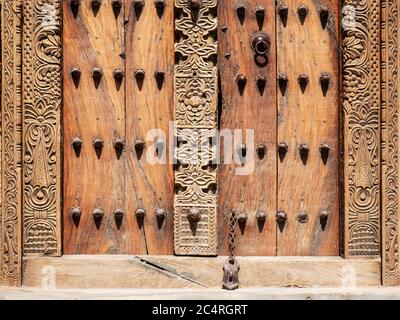 Porte en bois lourde avec des clous métalliques, des tours de montre dans le village de Mudayrib, Sultanat d'Oman. Banque D'Images