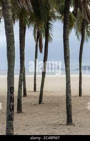 Vue sur les palmiers sur une plage vide de Copacabana Beach pendant l'épidémie de covid-19 à Rio de Janeiro, Brésil Banque D'Images