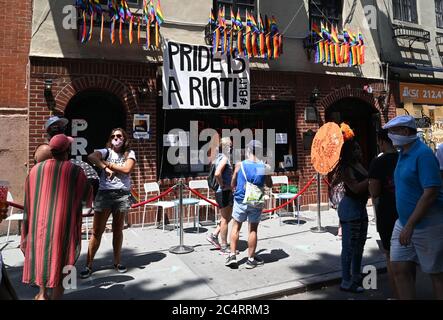 New York, États-Unis. 28 juin 2020. Une petite foule se réunit devant le légendaire bar Stonewall gay dans le West Village pour la Marche annuelle de la fierté le dimanche 28 juin 2020 à New York. Aucune manifestation n'a été autorisée cette année pour la première fois depuis 1970 dans ce qui est devenu une manifestation annuelle des droits civils. La ville de New York est entrée dans la phase 2 d'un plan de réouverture en quatre parties lundi après avoir été fermée pendant 3 mois en raison de la COVID-19. Photo de Louis Lanzano/UPI crédit: UPI/Alay Live News Banque D'Images