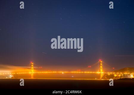 Le Golden Gate Bridge avec des nuages et des étoiles la nuit. Vue depuis Angel Island. Banque D'Images