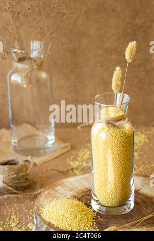 Millet dans un pot de verre sur un stand en bois, puis est une oreille de blé Banque D'Images