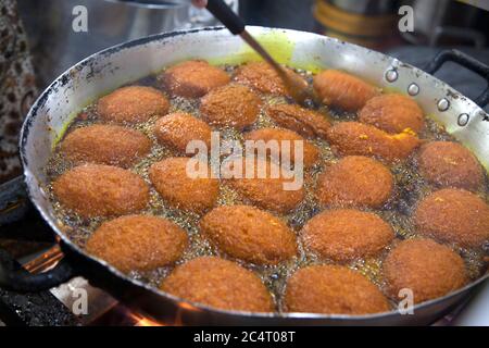 Acarajé, un plat vendu par des vendeurs de rue à Salvador de Bahia, Brésil, fait de haricots pelés et écrasés frits dans l'huile de dendê et souvent farcis avec des crevettes. Banque D'Images