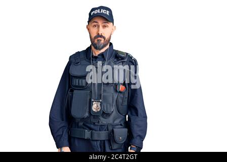 Jeune homme beau portant l'uniforme de police, qui a l'air endormi et fatigué, épuisé pour la fatigue et le hangover, les yeux paresseux le matin. Banque D'Images