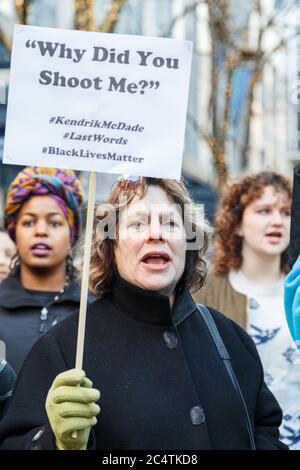 Seattle, États-Unis. 27 novembre 2015. Un manifestant caucasien tient un panneau mentionnant KKendric McDade, abattu par deux policiers en 2012. Banque D'Images