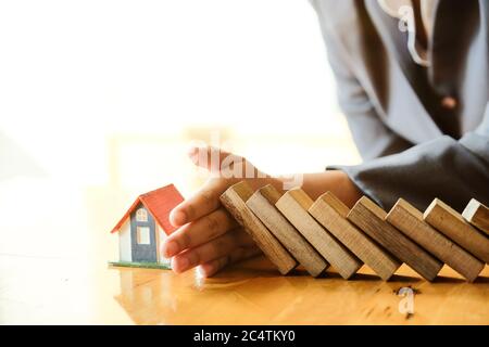 Protéger la maison de tomber sur les blocs de bois, assurance et concept de risque. Banque D'Images