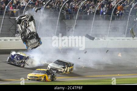 Daytona Beach, Floride, États-Unis. 17 février 2020. Newman vole après avoir été en tête en arrivant dans le tour final avec Ryan Blaney, quand le pare-chocs de Blaney a pris l'arrière de son Ford et a envoyé Newman dur dans le mur. Sa voiture s'est retournée, roulée, a été frappée du côté du conducteur par une autre voiture, et finalement a glissé sur la ligne d'arrivée, engloutie dans les flammes. Pendant ce temps, Denny Hamlin, gagnant du Daytona 500, est à proximité. Denny a remporté sa deuxième course droite de Daytona 500 et sa troisième victoire globale, battant Ryan Blaney dans une photo d'heures supplémentaires, marquée par l'effroyable accident qui a envoyé Ryan Newman à l'hôpital lundi. Banque D'Images