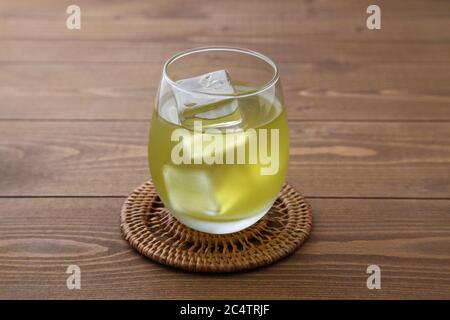 verre de thé vert froid isolé sur une table en bois Banque D'Images