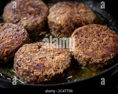 Hamburgers de bœuf frits dans une poêle. Gros plan sur des viandes hachées et juteuses maison dans une poêle à frire. Banque D'Images
