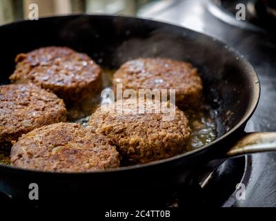 Hamburgers de bœuf frits dans une poêle. Gros plan sur des viandes hachées et juteuses maison dans une poêle à frire. Banque D'Images