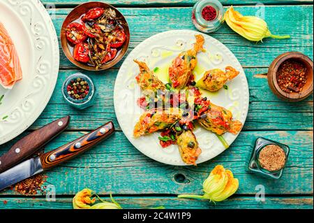 Fleurs de courgettes frites farcies de saumon et de tomates séchées. Banque D'Images