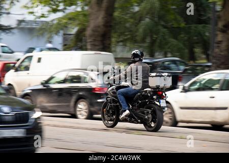 Homme à vélo dans la circulation urbaine animée sur la piste de tramway, de derrière Banque D'Images