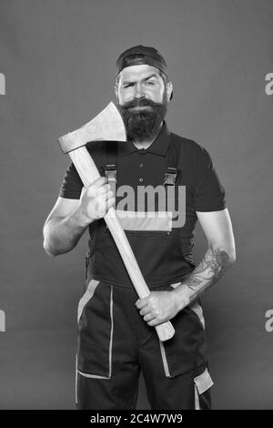homme avec hache. forester tenir la hache. homme en uniforme couper les cheveux de barbe avec hache. homme barbu brutal utiliser hache dans les mains. Randonnée vacances. Assez courageux. Utilisez la lame dans le barbershop. Brutal et barbu. Banque D'Images