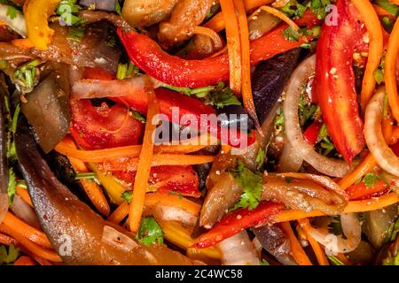 Vue de dessus sur la salade de légumes d'aubergines, carottes, oignons, poivrons aux épices orientales gros plan Banque D'Images