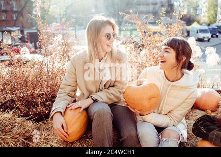 Les filles tient les citrouilles dans les mains sur le fond de la rue. Banque D'Images