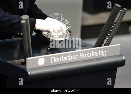 Berlin, Allemagne. 29 juin 2020. Un huissier renverse un verre d'eau au lectern lors de la session extraordinaire du Bundestag allemand sur la réduction prévue de la taxe sur la valeur ajoutée à partir de 01.07.2020. La réduction de la taxe sur la valeur ajoutée, qui est limitée à un demi-an, fait partie du plan de relance économique du gouvernement fédéral pour stimuler l'économie dans la crise de Corona. Credit: Kay Nietfeld/dpa/Alay Live News Banque D'Images