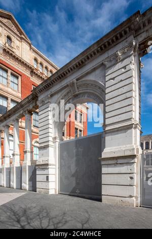 Vue oblique de l'écran montrant les dégâts à la bombe et le lettrage par David Kindersley. Sackler Courtyard Gate, Victoria & Albert Museum, Londres, Royaume-Uni Banque D'Images