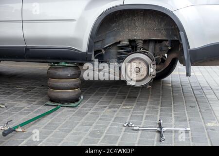 La voiture est soulevée au service après-vente pour le pneu, vue de près. Banque D'Images