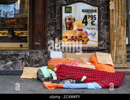 Un homme sans abri dormant à l'extérieur d'un restaurant McDonalds, à l'angle de la Calle de la Montera et de la Gran via, Madrid, Espagne. Banque D'Images