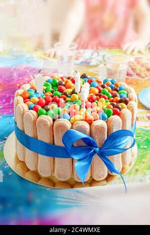 un grand gâteau charmant décoré de bonbons colorés sur un fond coloré. En-cas pour les enfants pour un anniversaire et des vacances en famille. Banque D'Images