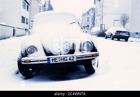 VW Beetle garée dans une rue enneigée, Solingen, Allemagne. Banque D'Images