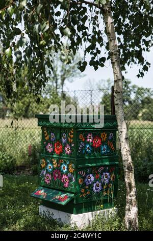 Zalipie, Pologne, juin 2020 : ruche traditionnelle, ancienne, en bois décorée de motifs floraux et de peintures florales. Maison d'abeilles peinte à la main. L’art populaire Banque D'Images