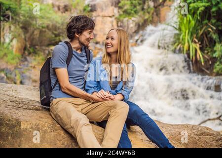 Couple de touristes avec un sac à dos sur le fond d'une cascade Banque D'Images