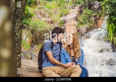 Couple de touristes avec un sac à dos sur le fond d'une cascade Banque D'Images