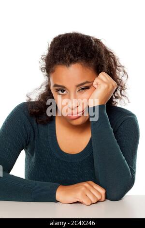 portrait d'une jeune femme malheureuse à la peau sombre sur fond blanc Banque D'Images