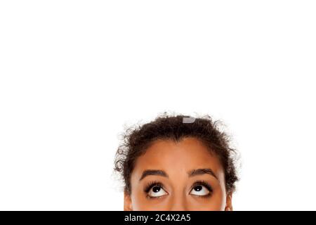 demi-portrait d'une jeune fille à la peau sombre qui regarde sur fond blanc Banque D'Images