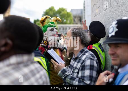 Un homme lit un livre devant une statue de Winston Churchill lors de la démonstration de Black Lives Matter, Parliament Square, Londres, 21 juin 2020 Banque D'Images