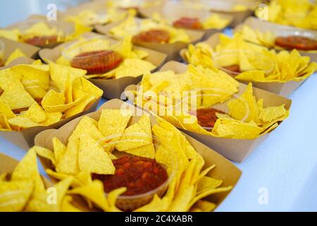Nachos croustillants savoureux avec ketchup dans un contenant en papier. Concept de restauration rapide malsaine Banque D'Images