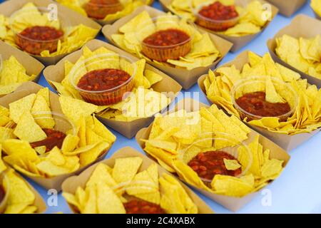 Nachos savoureux avec ketchup dans un contenant en papier. Concept de restauration rapide malsaine Banque D'Images