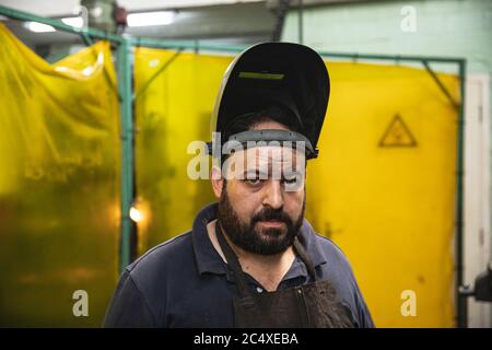 Portrait d'un ouvrier de l'usine portant un masque de soudage à l'usine Banque D'Images