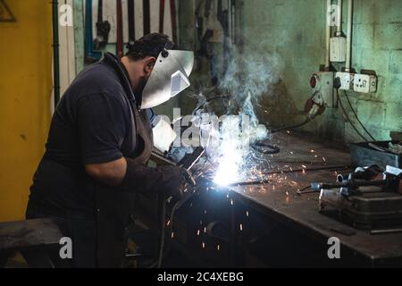 Un ouvrier de l'usine portant un masque de soudage à l'usine Banque D'Images