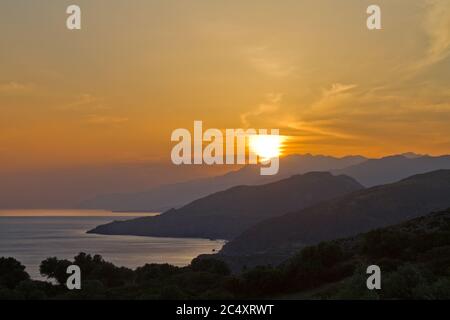 Silhouettes de collines sur la côte de Crète au coucher du soleil Banque D'Images