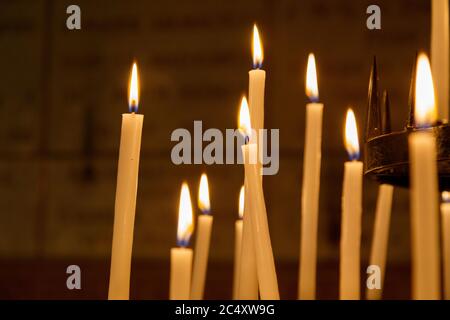 Lumière des bougies dans l'église sur fond noir. Concept de spiritualité et de foi. Banque D'Images